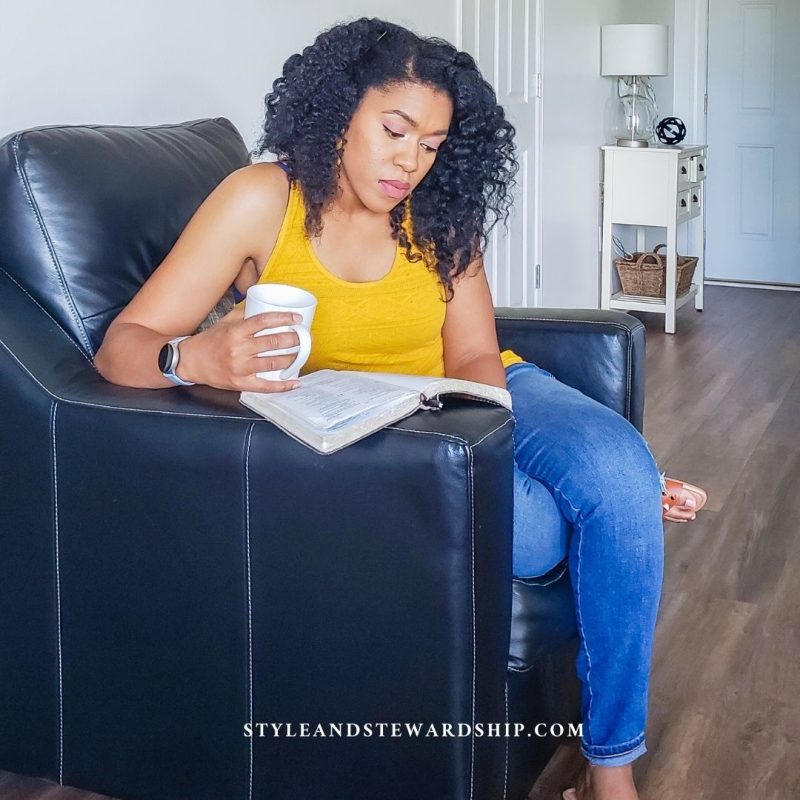 Style And Stewardship - Woman reading from the bible sitting and drinking coffee