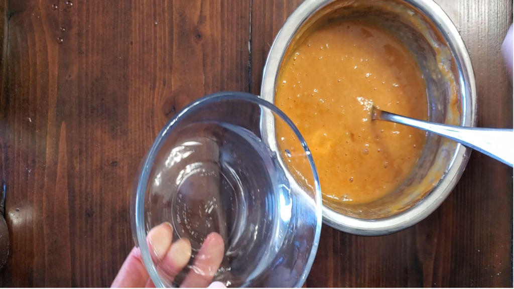 Melted oil being poured into a orange mixture