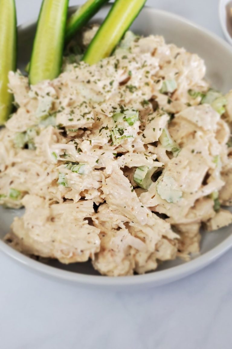 Large white plate with chunky chicken salad and pickle spears.
