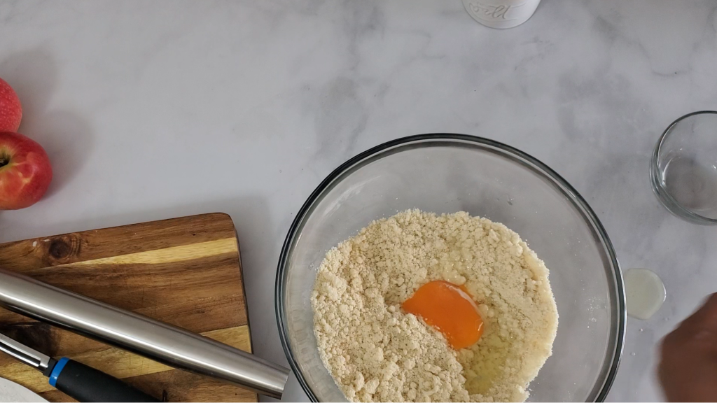 An egg being added to flour mixture