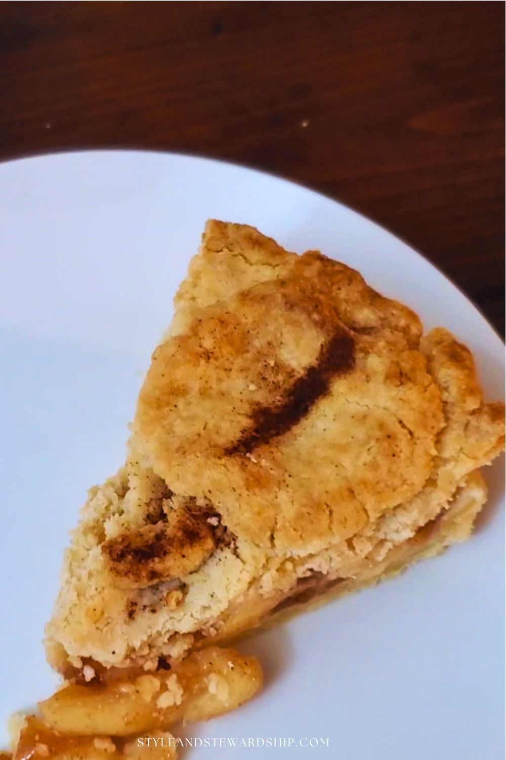 Golden slice of apple pie with cinnamon design on top