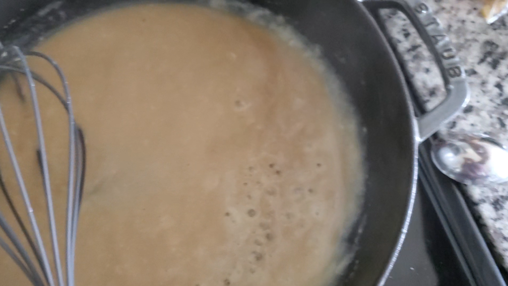 a whisk in a cast iron pan mixing gravy