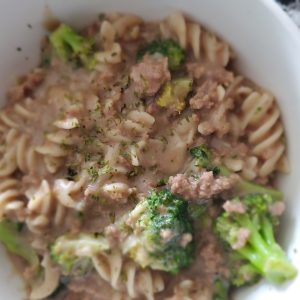 white bowl with creamy rotini noodles, ground beef and broccoli