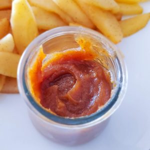 Date caramel dip with sliced apples on a white plate
