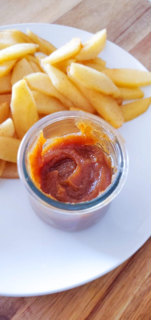 Date caramel dip with sliced apples on a white plate