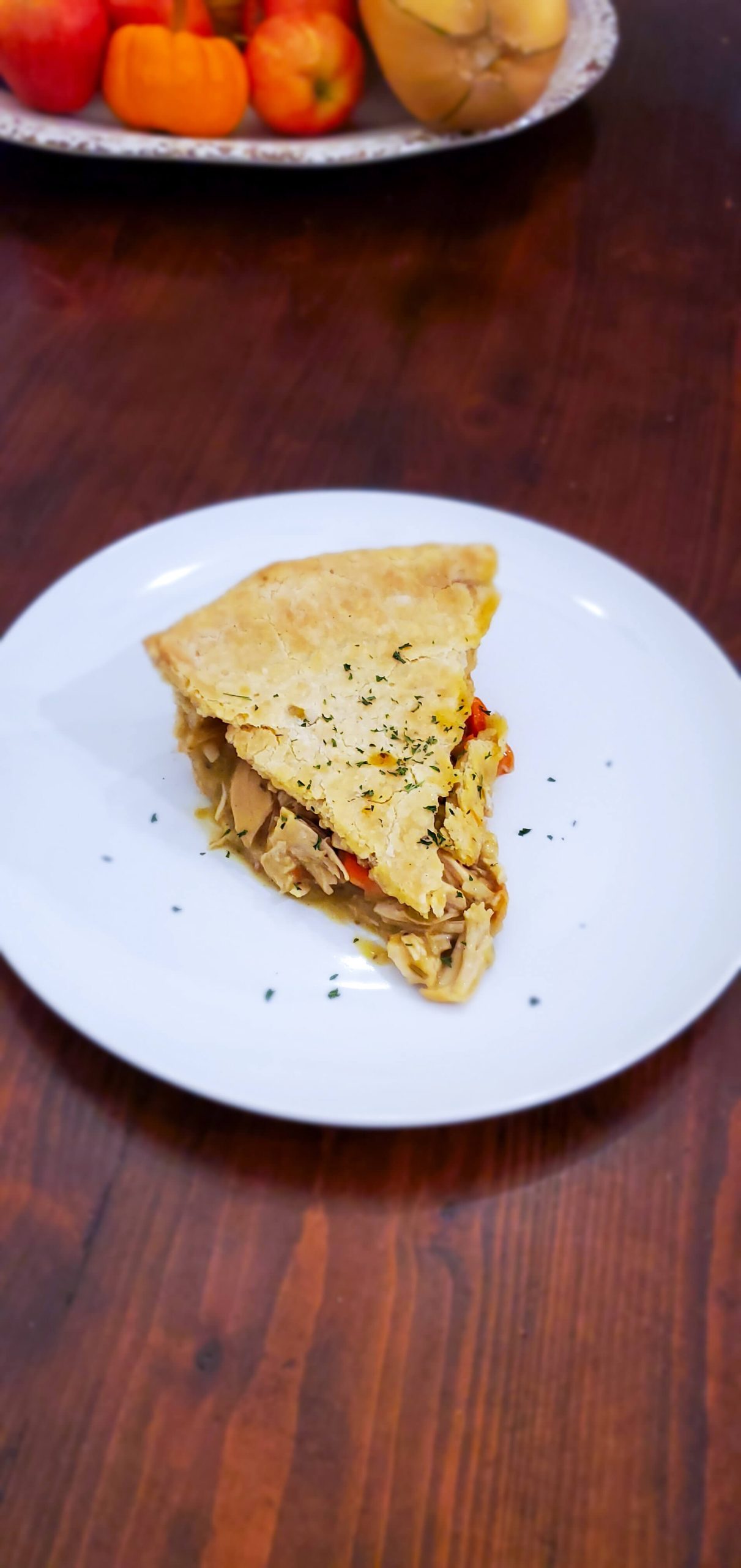 A slice of gold crust chicken pot pie on a white plate