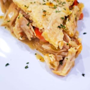a slice of chicken pot pie on a white plate