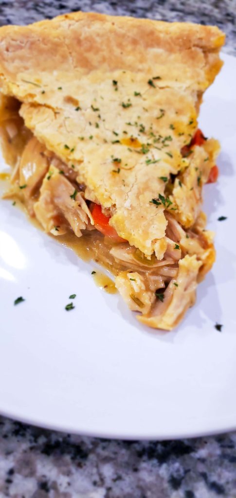 a slice of chicken pot pie on a white plate