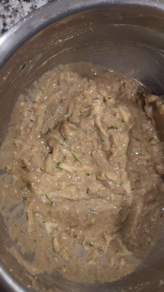 zucchini bread batter in a stainless mixing bowl